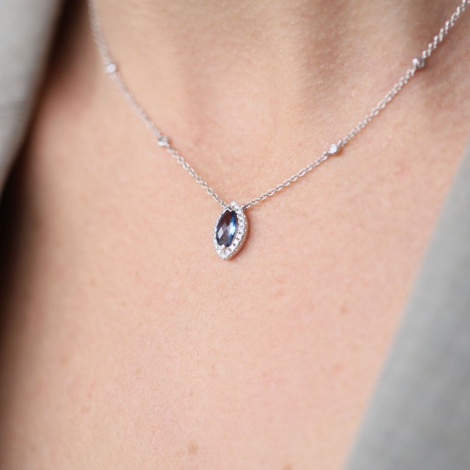 18ct White Gold Marquise London Blue Topaz And Diamond Halo Pendant With Diamonds On The Chain