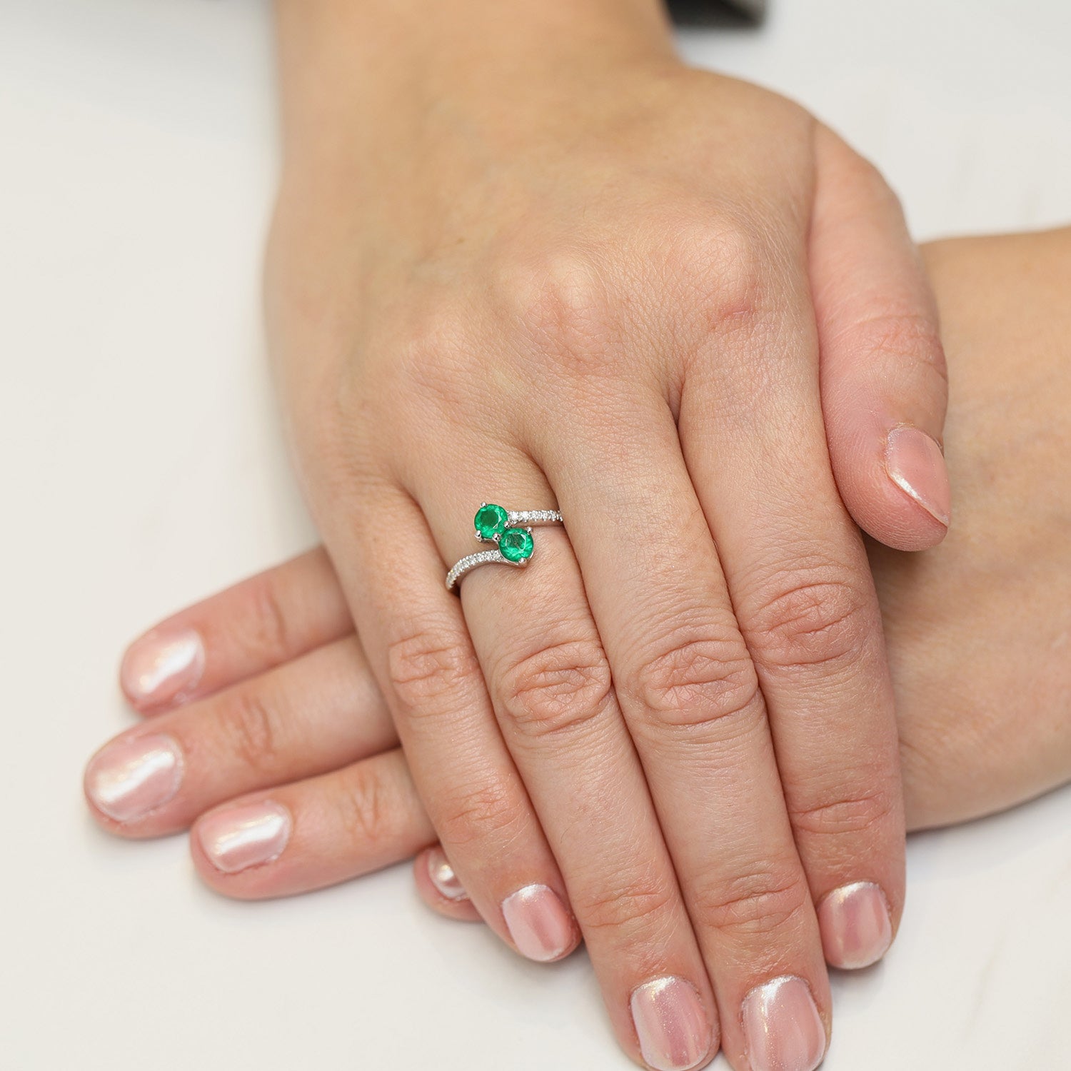 Platinum Round Brilliant Cut Emerald Two Stone Twist Ring With Diamond Set Shoulders