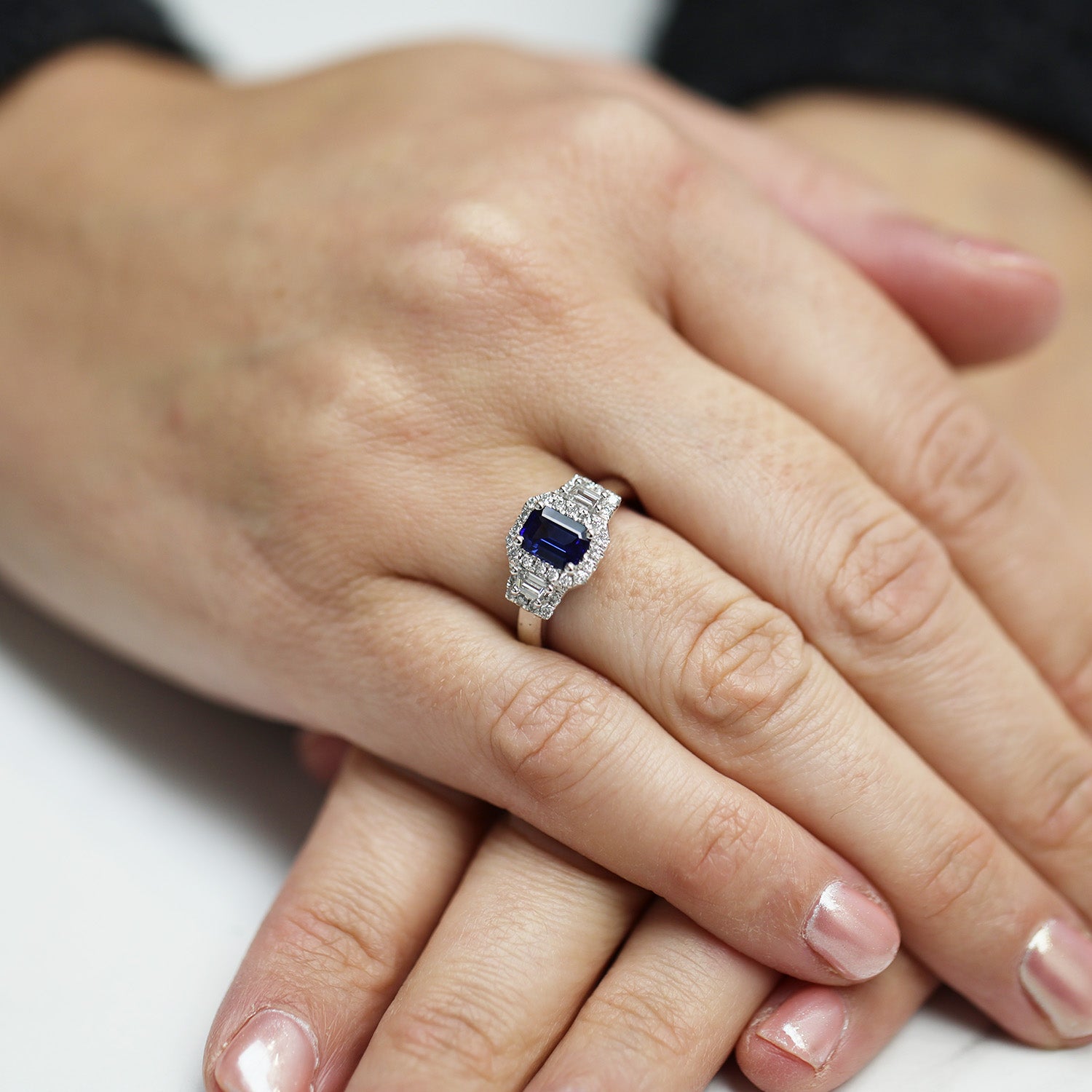 Platinum Sapphire And Baguette Cut Diamond Three Stone Ring With A Halo Surround