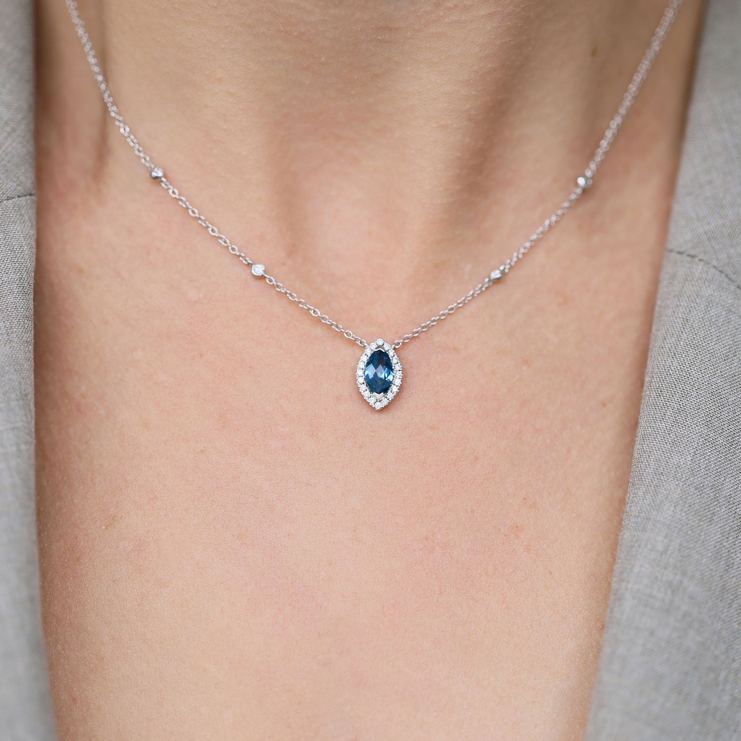 18ct White Gold Marquise London Blue Topaz And Diamond Halo Pendant With Diamonds On The Chain