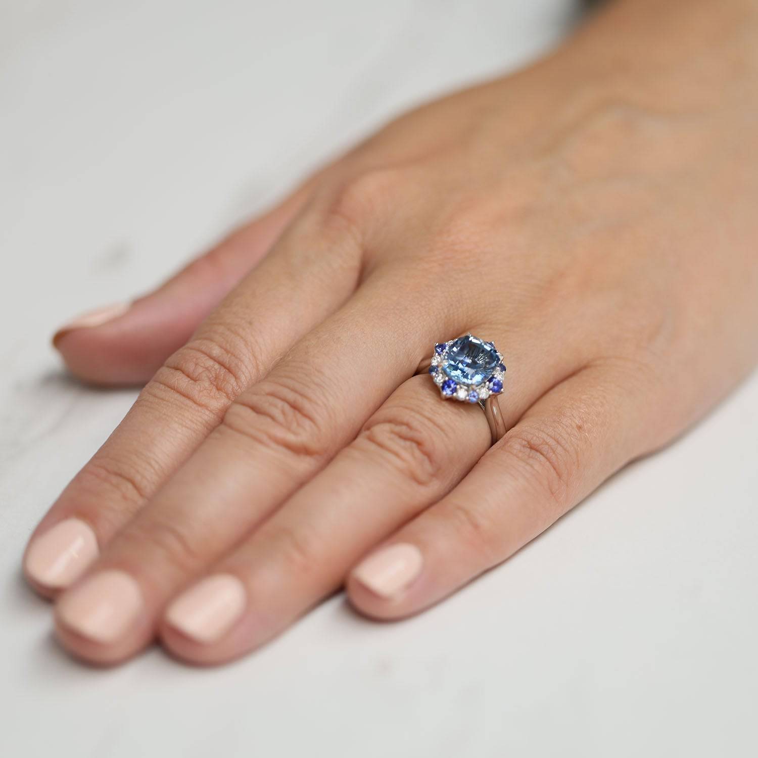 Platinum Cushion Cut Aquamarine Halo Dress Ring With Alternately Set Blue Sapphire and Diamonds.