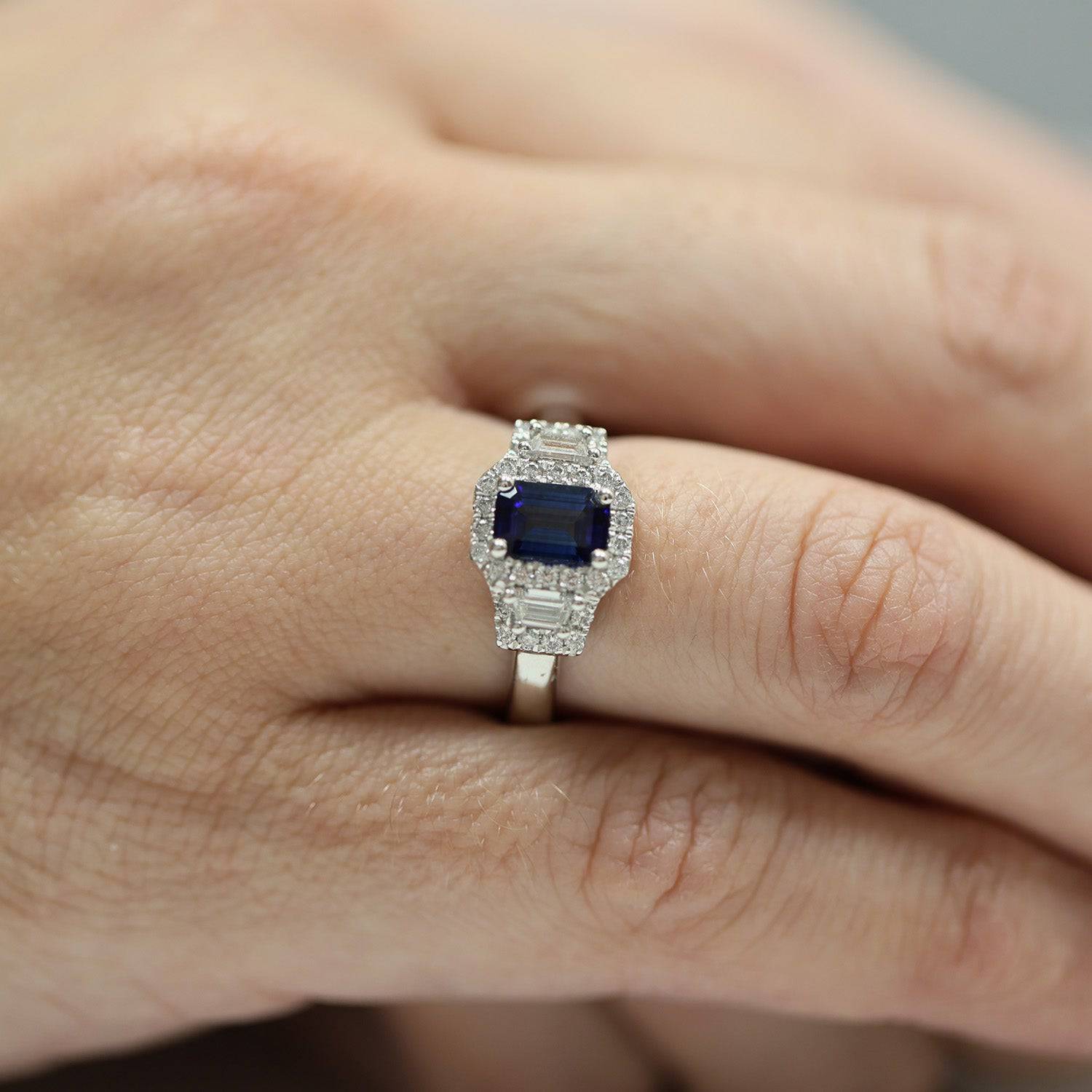 Platinum Sapphire And Baguette Cut Diamond Three Stone Ring With A Halo Surround